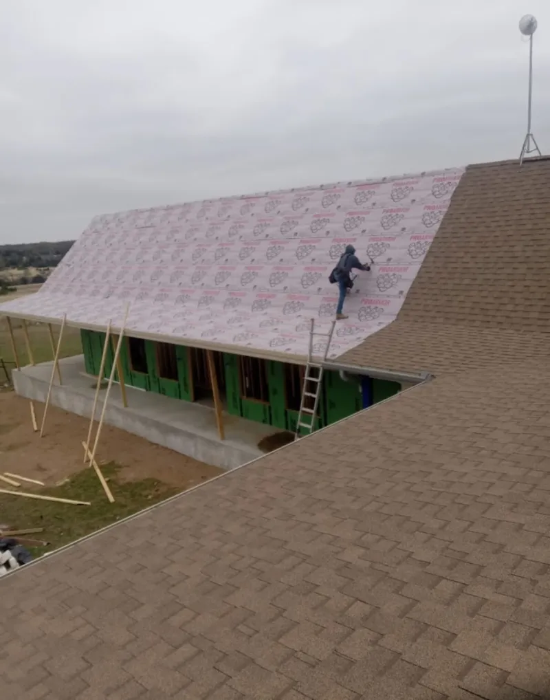 Worker preparing underlayment for a metal roof installation in North Middleton